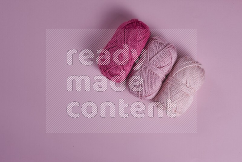 A pink collection of sewing and tailoring tools arranged on a pink background