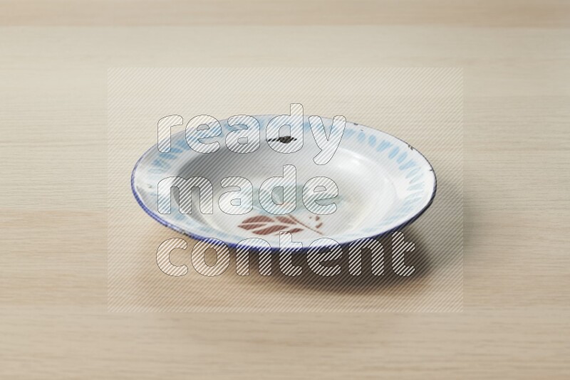 A vintage metal plate on light wooden background