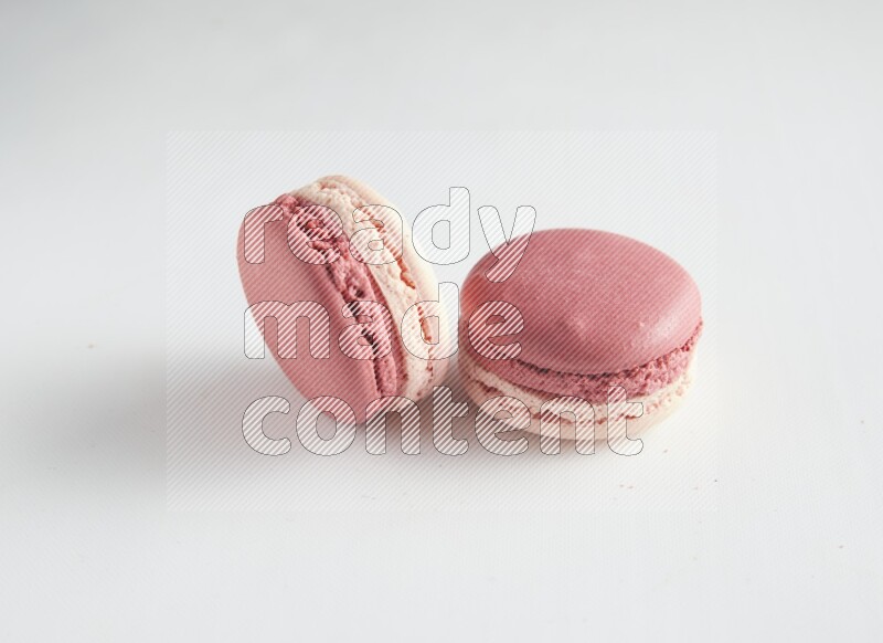 45º Shot of two Pink Litchi Raspberry macarons on white background