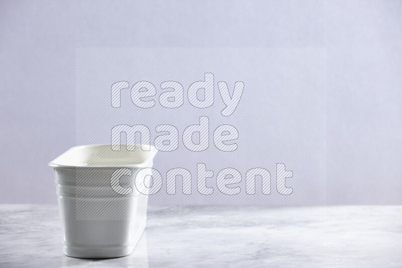 An empty white plant pot on grey marble background