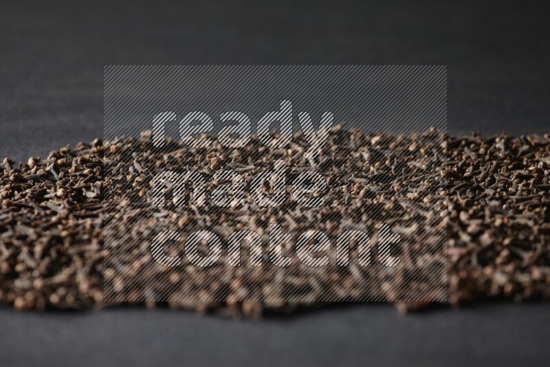 Cloves spread on black flooring