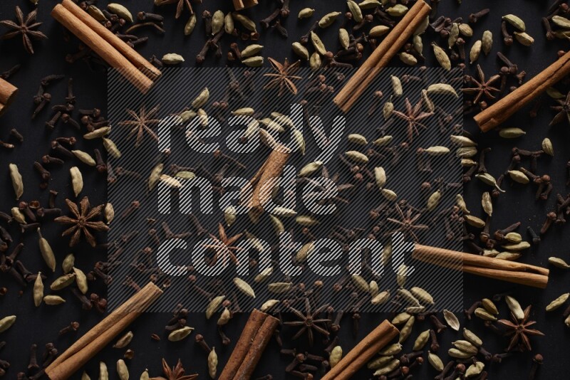 Cinnamon Sticks, Star anise, Cardamom and cloves on a black background