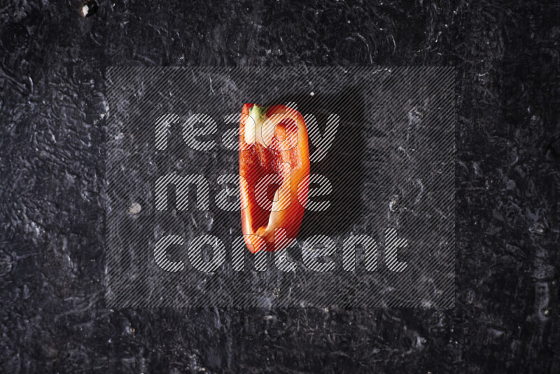 Red bell pepper slices on black background