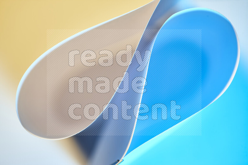 An abstract art of paper folded into smooth curves in blue and yellow gradients