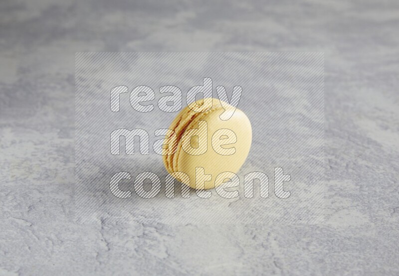 45º Shot of Yellow Vanilla macaron on white  marble background