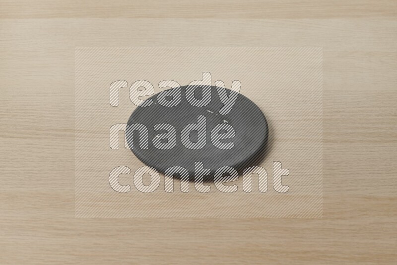 A pottery coaster on light wooden background