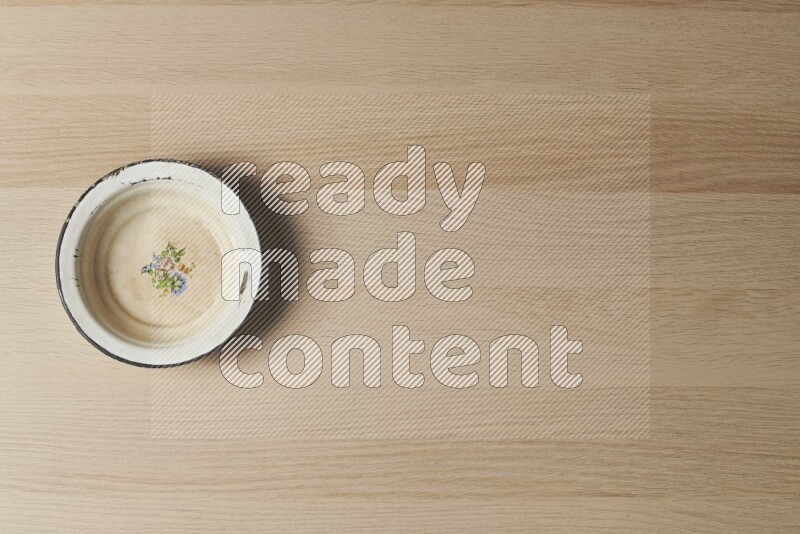 صحن معدني عتيق على خلفية خشبية فاتحة