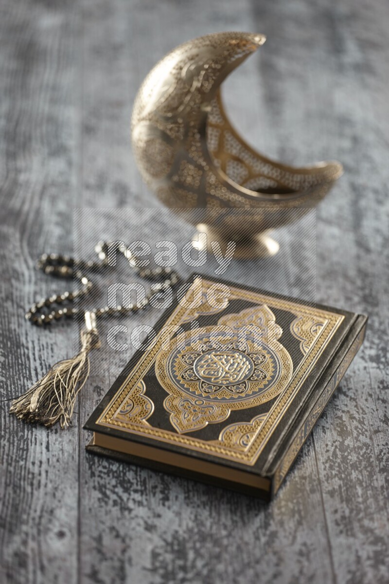 A silver lantern with different drinks, dates, nuts, prayer beads and quran on grey wooden background