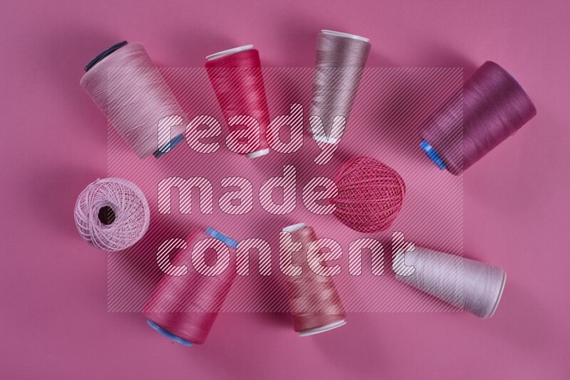 A pink collection of sewing and tailoring tools arranged on a pink background