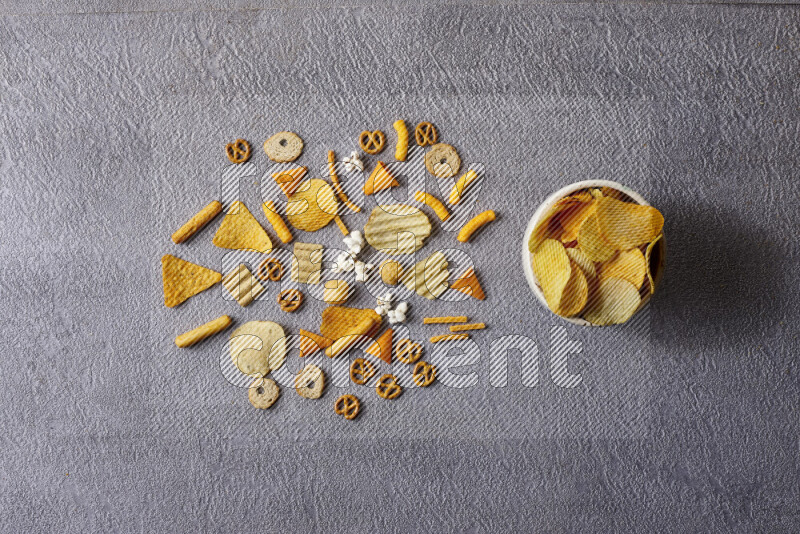 Assorted snacks in pottery bowls on grey background
