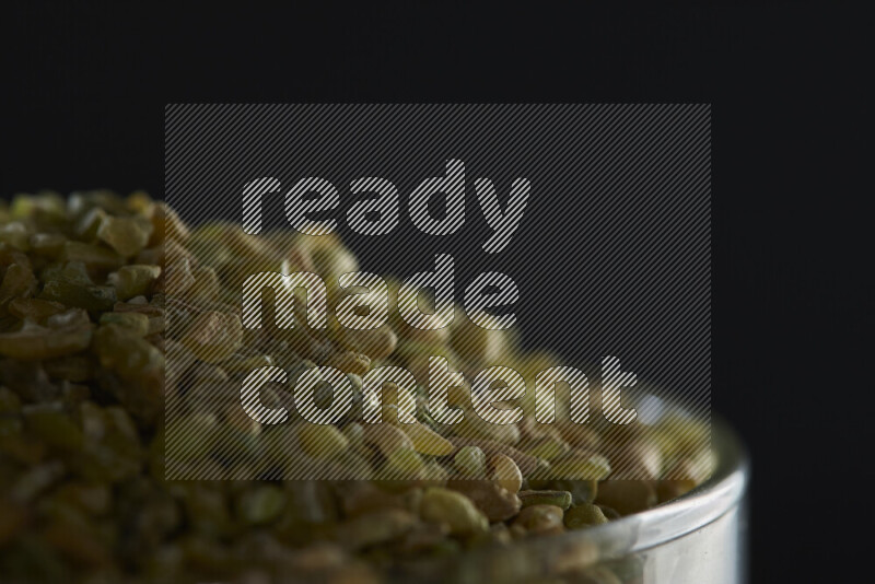 Freekeh in a glass jar on black background
