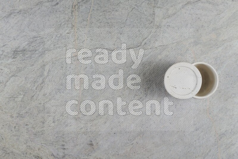 كأس فخاري متعدد الألوان على خلفية من الرخام الرمادي