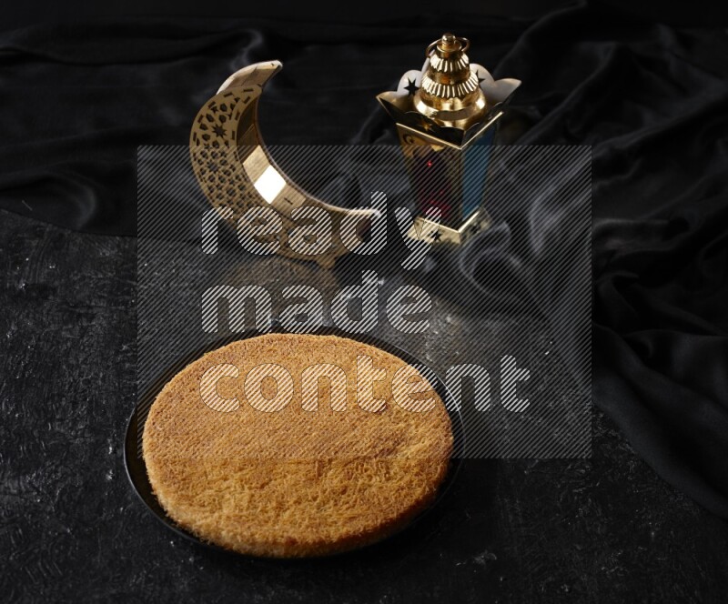 كنافة مع فوانيس علي خلفية سوداء خشبية