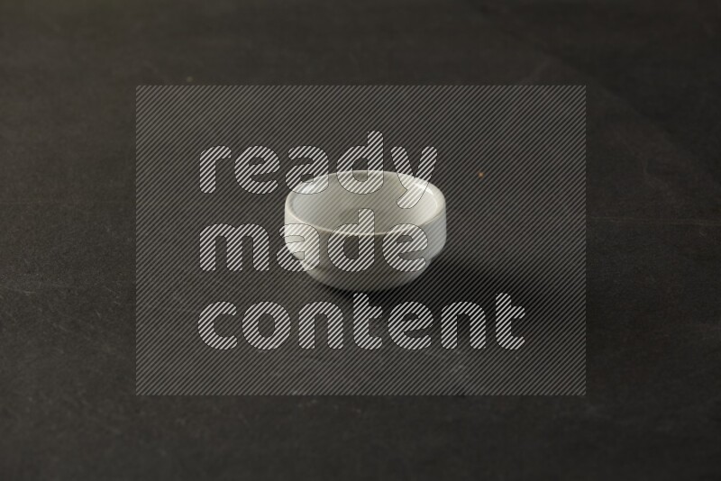 white ceramic round sauce bowl on grey textured countertop