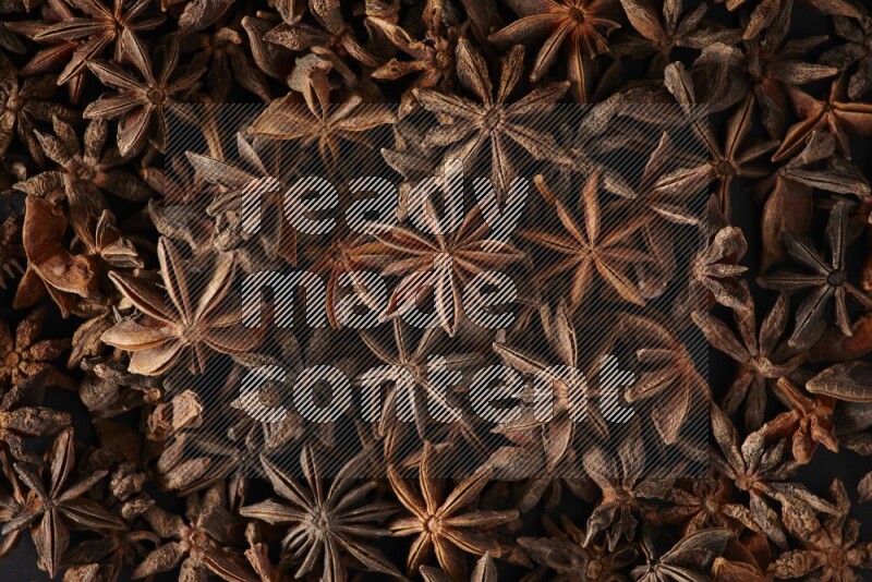 Star Anise herbs fill the frame on black flooring