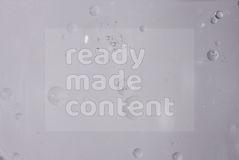 قطرات من الزيت على سطح الماء على خلفية بيضاء