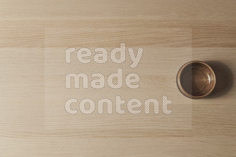 وعاء فخاري بيج على خلفية خشبية فاتحة