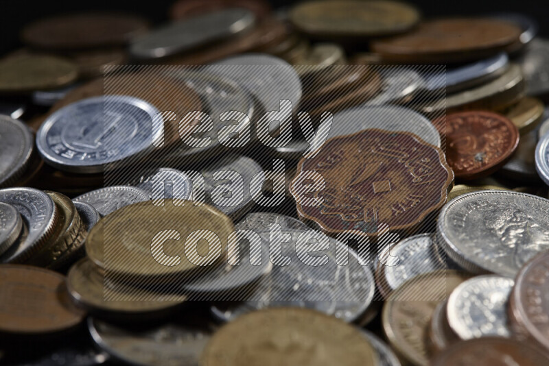 A close-ups of random old coins on black background