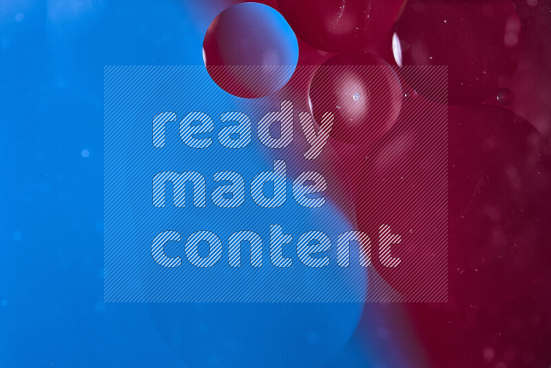 لقطات مقربة لفقاعات من الزيت على سطح الماء باللون الأزرق والأحمر