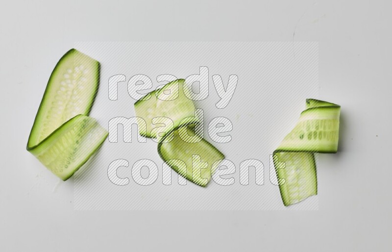 Three cucumber ribbons on a white background