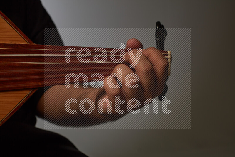 a hand intracting with a wooden brown Oud