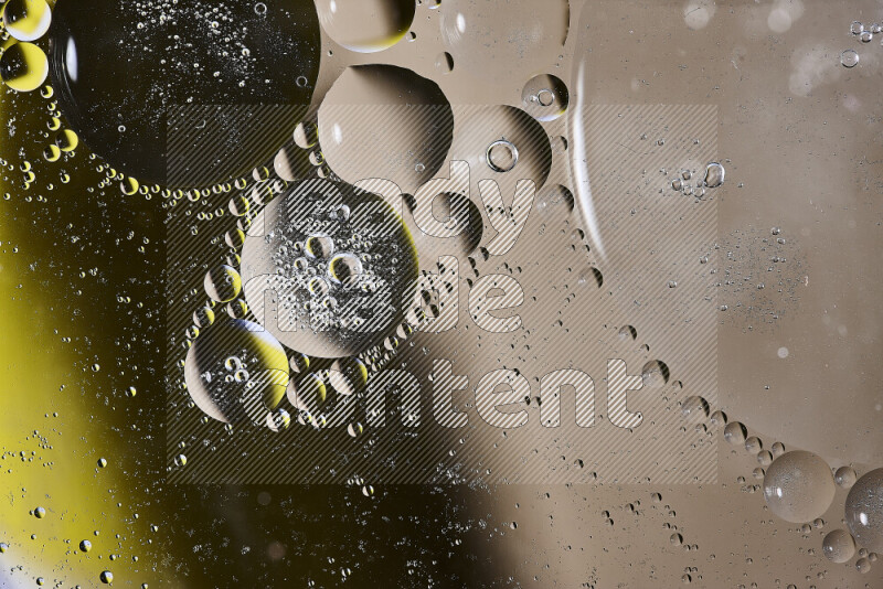 Close-ups of abstract oil bubbles on water surface in shades of brown, black and yellow
