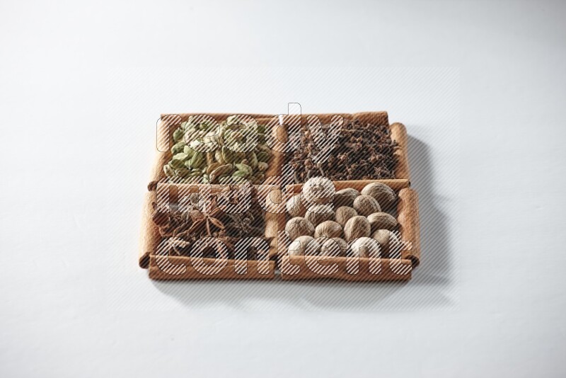4 squares of cinnamon sticks full of cardamom, star anise, cloves and nutmeg on white flooring